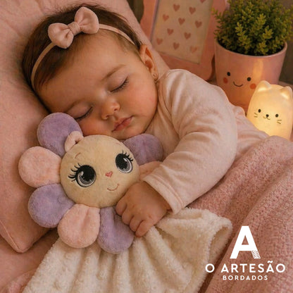 Matriz de bordado naninha florzinha lilás abraçada por bebê dormindo em berço cor-de-rosa